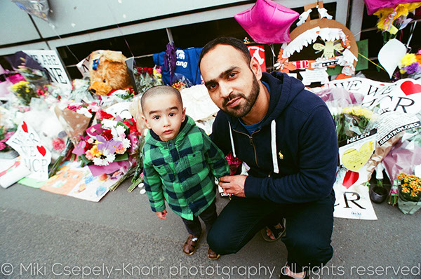 A colour image of a father and son in St Ann's Square, Manchester